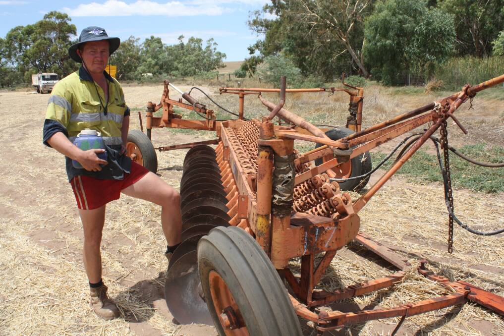 Mingenew farmer Andrew Cosgrove next to an 18-disc one-way plough that was later sold on an opening bid of $250.