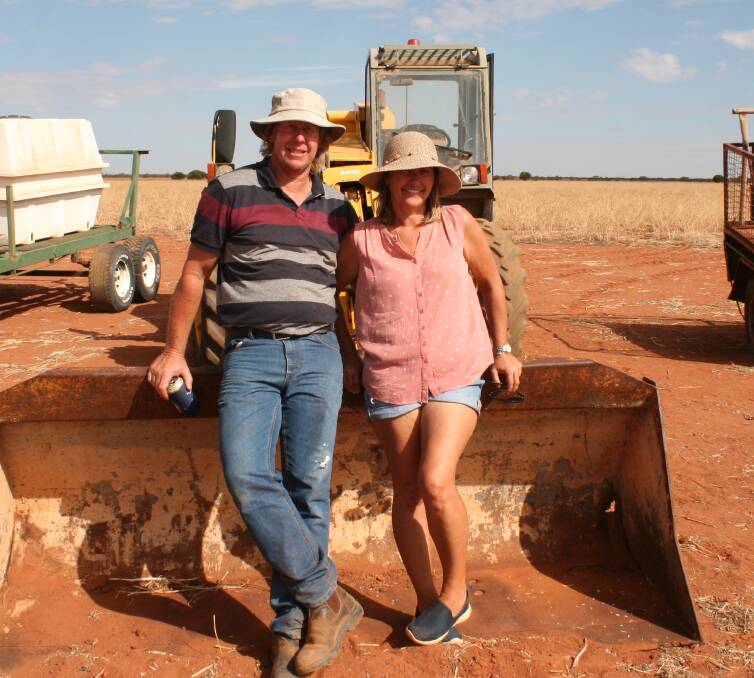 Greg Cole (left) and his wife Linda made the trip to Gutha from Dongara. They had a rest on this loader bucket, which neared the end of the sale. The JCB telehandler and bucket sold with the trailer on the right for $7000.