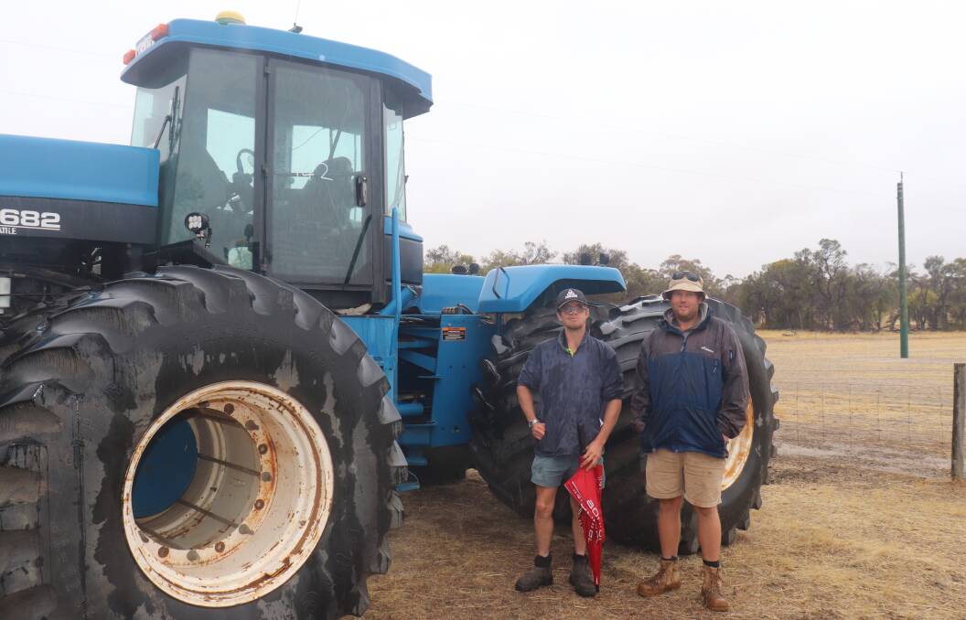 Scott Bolt (left) and Reece Taylor, Wagin, next to a New Holland Versatile 9682 4WD tractor with a N14 Cummins engine (7691 hours) that sold for $47,000.
