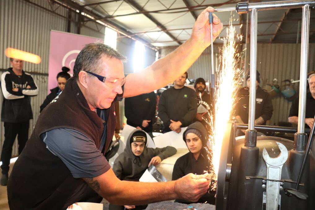 Heiniger Australia territory sales manager Todd Wegner demonstrates sharpening cutters at the shearing school. Heiniger provided the handpieces, combs and cutters used at six schools and provided each graduate with a singlet and polo shirt.