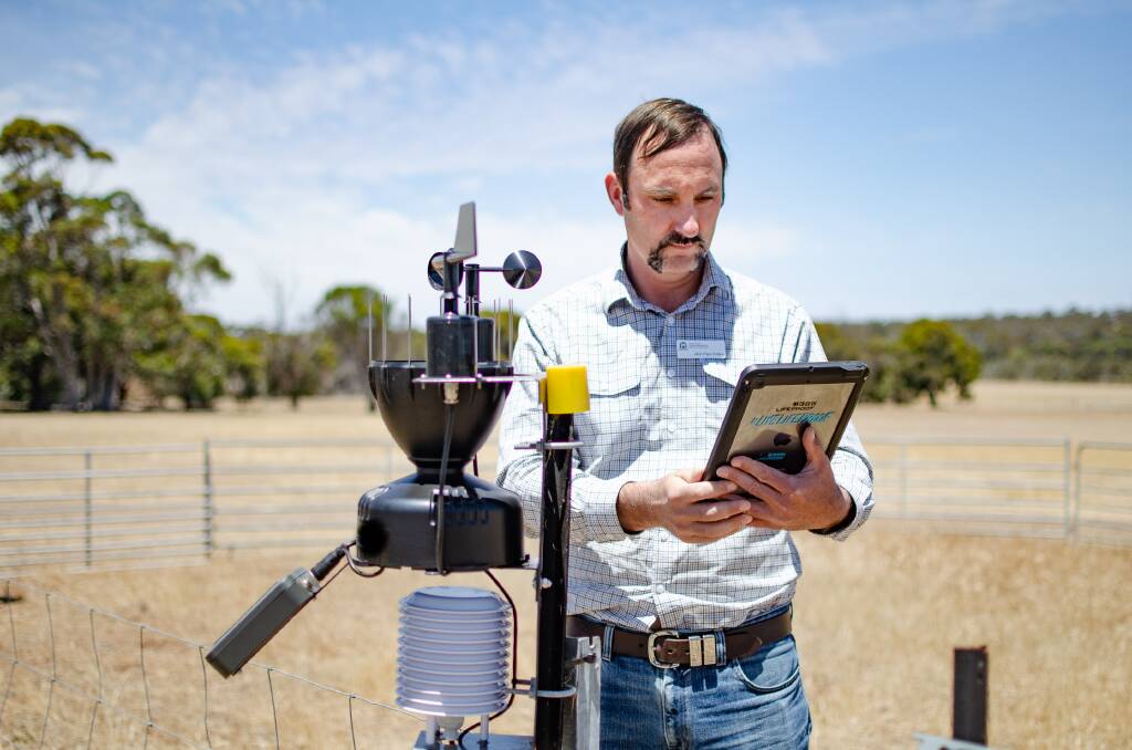 DPIRD research officer John Paul Collins examines a new automated weather station at the Katanning Research Facility, installed as part of an ag-tech upgrade.