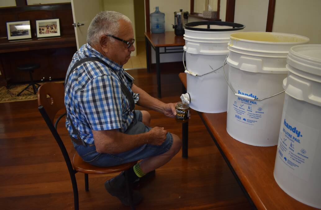 Noongar Land Enterprise Group's apiarist (beekeeper) Malcolm Clifford pours the first batch of Ngooka Honey.