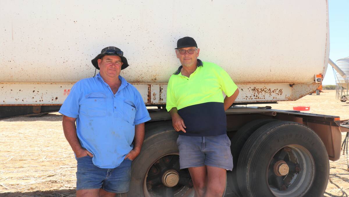 Shade was at a premium in the Kulja paddock where the Lang familys Bresland Farming machinery and equipment were displayed, but Andrew Tunstill (left), Burakin and Ian Wood, Carani, found some beside a Howard Porter five-axle dog trailer that Mr Tunstill later bought with a bid of $50,000.
