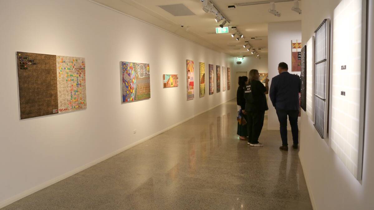 Brian McKinnon discusses his artwork with visitors at the Geraldton Regional Art Gallery.
