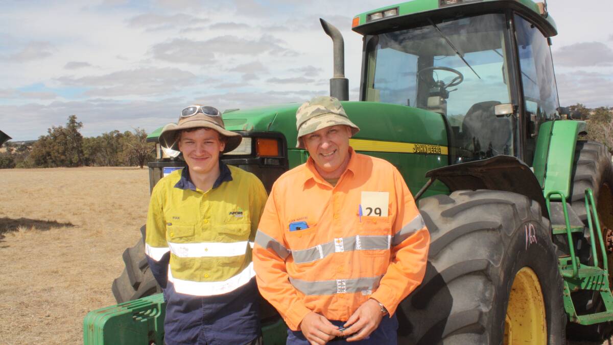Ryan Martin (left), Jelcobine and his father Ian next to the John Deere 8100 front wheel-assist tractor on rear duals that sold for $32,500 to a Kojonup concern.
