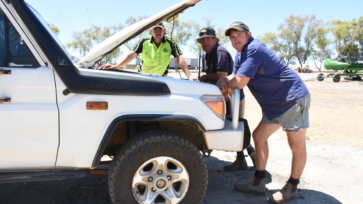 Scott (left), Greg and Mitch Cocking, Wannamal, had the bonnet up on the 2013 Toyota LandCruiser ute which was in the sale line-up. The ute which had 206,070km on the clock sold for $55,000 after the selling team took an opening bid of $42,000.