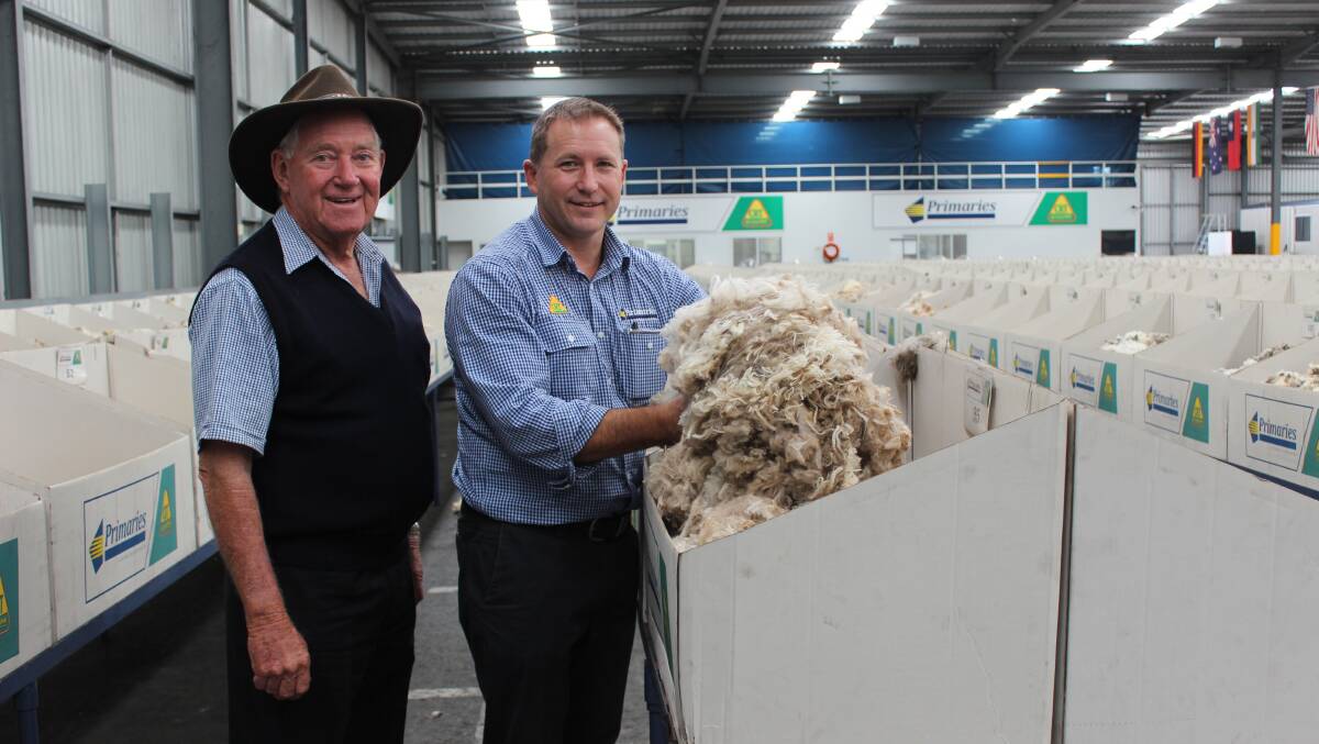 Three Springs farmer Anthony Thomasn (left) on the Primaries of WA show floor with wool manager Greg Tilbrook and some of the strong wool fleece from a six-month shearing.