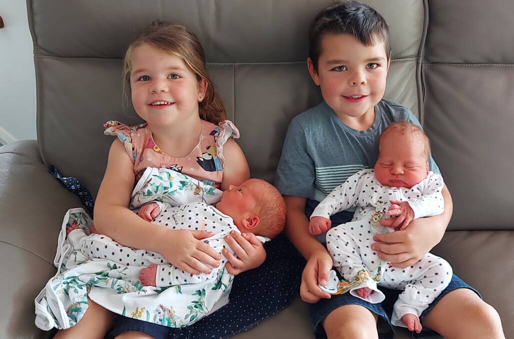 Big sister and brother Kyra, 4 and Curtis (now 6) holding their twin brothers, Malakai (left) and Logan.