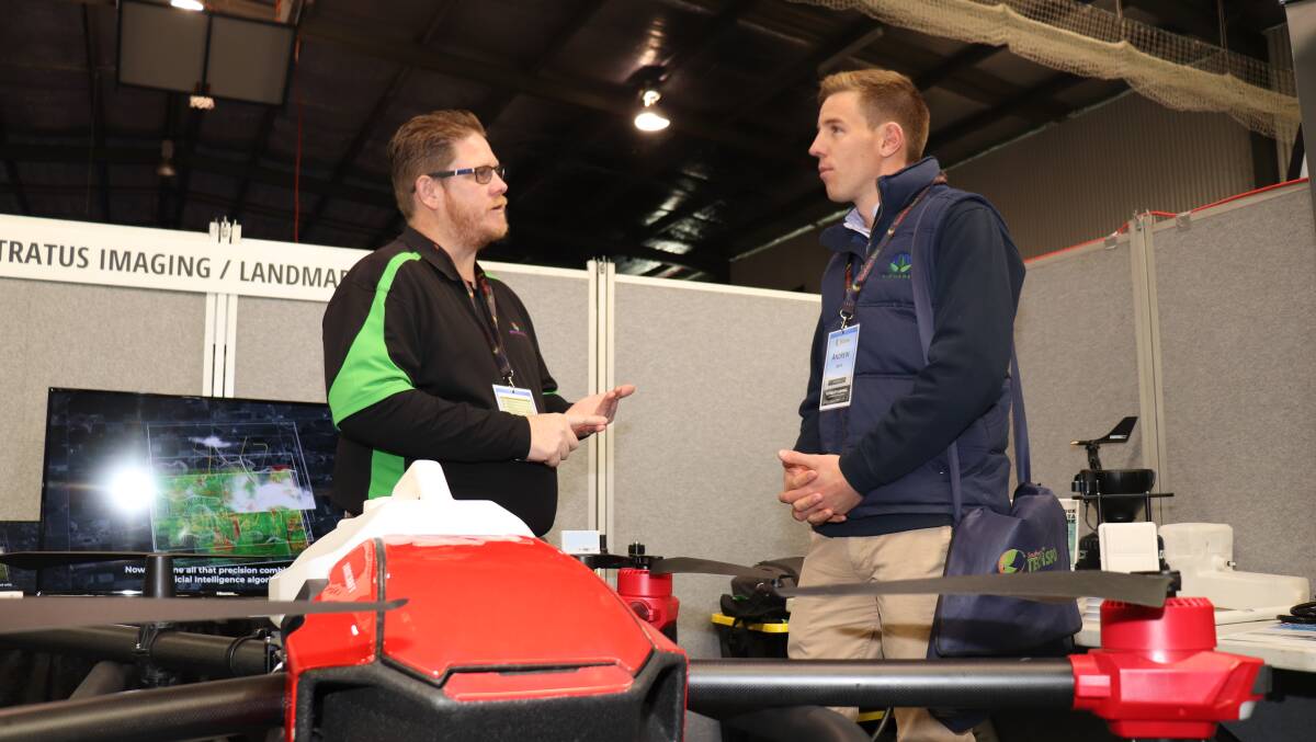 Jonathon Smith (left), Stratus Imaging, chats with Farmanco consultant Andrew Smith at last week's TECHSPO about the AeroShield drone spraying service using the XAG P30 drones, pictured in action below.