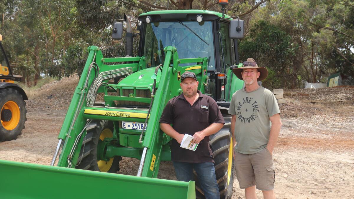  Karl Ivers (left), Esperance and Dave Andrews, Mount Nasura, inspecting the John Deere 6430 FWA tractor with a 2.4m bucket, which reached the sale's top price of $90,000.