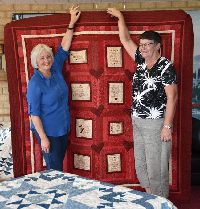 Heather Jefferies (left), from the Quilting Barn at Duranillin and patchwork, quilting and appliqué head steward Lyn Pike with Wendy Pederick's work that won the best in the section last year.