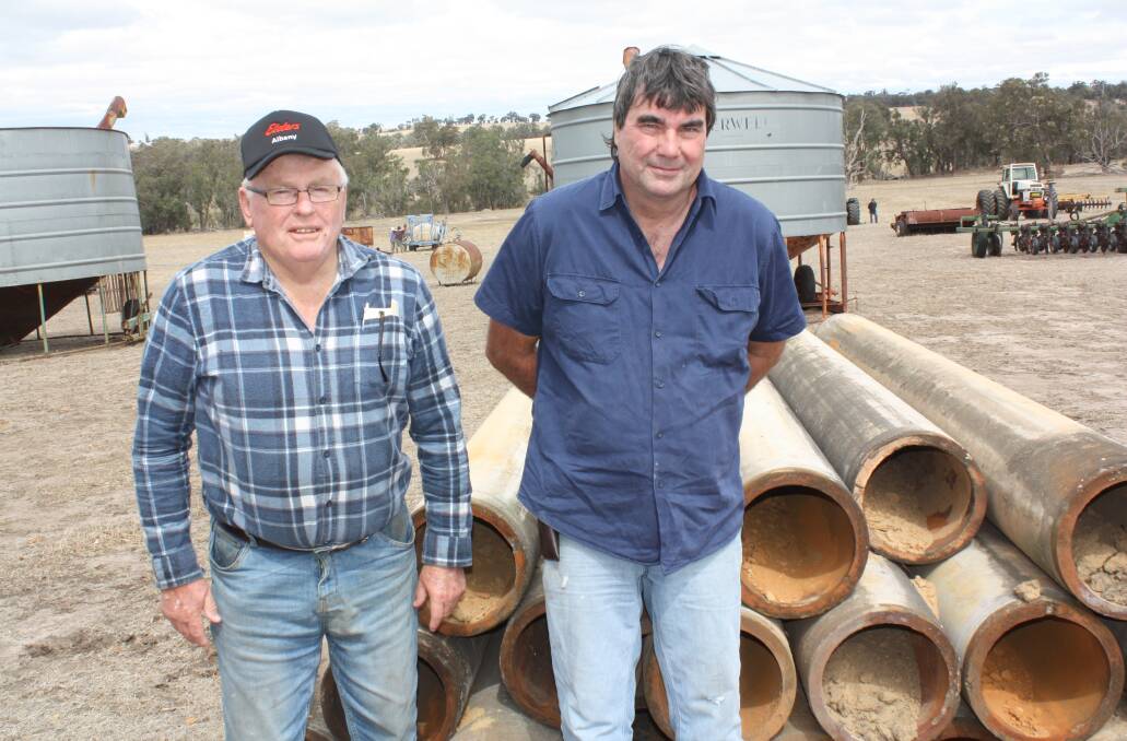 Porongurup farmers Geoff Reid (left) and Allan Rees had their collective eyes out for useful items. There was a lot of interest in these 18 cement culvert pipes and one buyer took the lot after a jousting of bids was finalised at $250 per pipe.