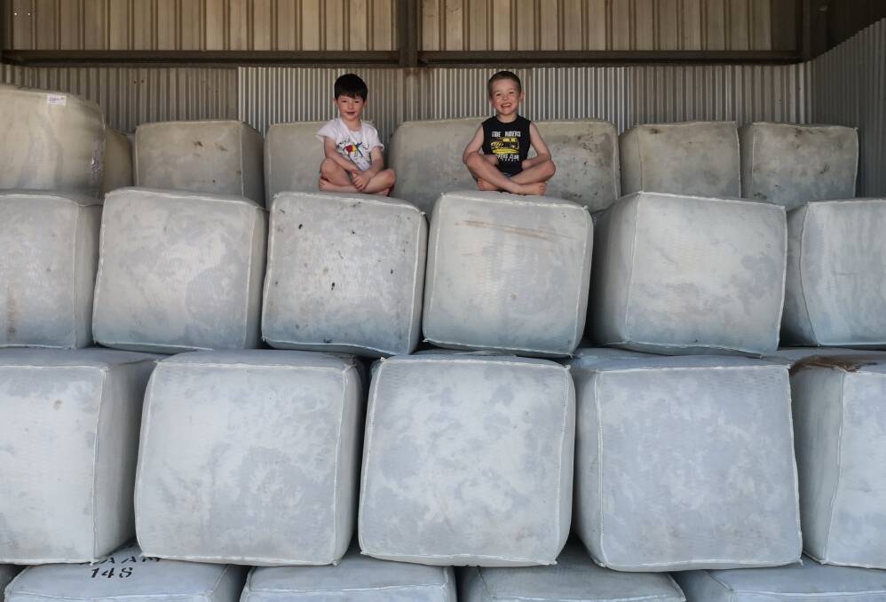 Verne (left) and Lawson Saunders atop some of the wool bales at the farm.