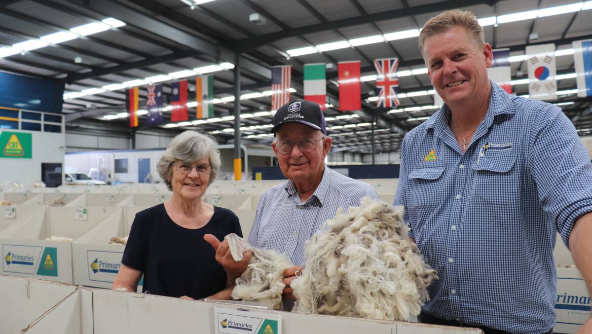 Inspecting their 50th clip on the Primaries of WA show floor before it was merged into Nutrien Ag Solutions in 2020 are Alison and Mal Ballard, Kojonup, with Stephen 'Squizzy' Squire who is only the third wool broker in 50 years to market the Ballards' wool.