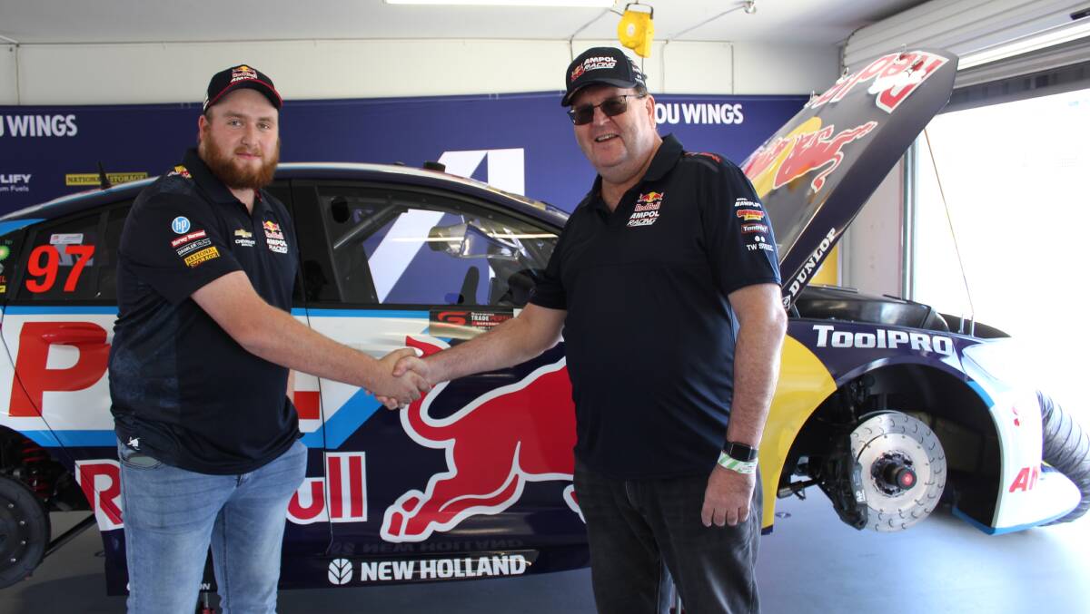 McIntosh & Son Wongan Hills service parts technician Daniel Just (left), is congratulated by New Holland Australia and new Zealand general manager Bruce Healy on being the first New Holland apprentice, technician or manager to win a weekend as part of the Red Bull Ampol Racing pit crew.