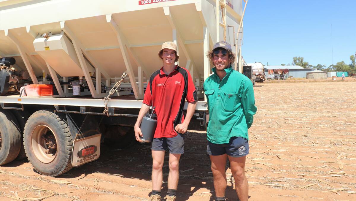 Brothers Oscar (left) and Angus Rogers, Cunderdin, beside a near-new condition Conquest Smart Bin mounted on an older tandem drive ACCO 2250 diesel tray truck. It later sold to Gen Y Grazing, Northam, who jumped into the bidding late and claimed it for $106,000.