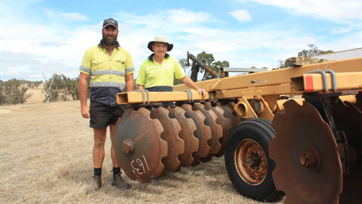 Jamie (left) and Ron Miller, Dudinin, next to a Ezee-On offset disc plough that attracted spirited bidding up to $21,000. At that point it was passed-in.