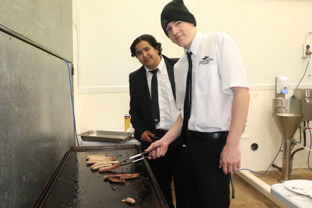  Year 11 student Kawrihana Whareaorere (left), York and year 12 student Liam Gale, Toodyay, cooking sausages for visitors to the colleges abattoir and butchers shop.