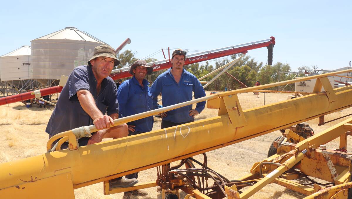 Neville Messenger (left), Rodney Bowring and Aiden Bligh, all of Brookton, checking out one of several grain augers which sold to a top of $36,000.