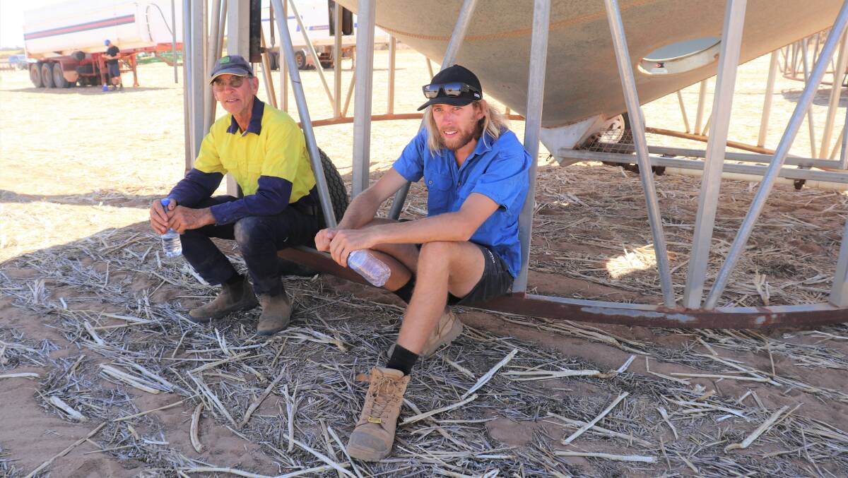 Father and son James (left) and Tim Bremner, Beverley, take a break in the shade of a 45 tonne field bin.