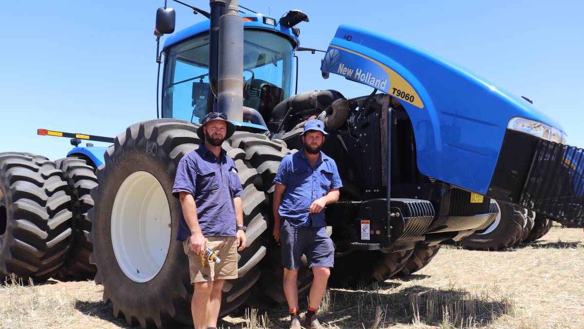 Three big New Holland tractors in excellent condition attracted plenty of tyre kickers and all sold. Here, Craig Walker (left) and Daniel Spencer from Bencubbin check out one of two identical 2009 New Holland T9060 402kW (540hp) 4WD tractors.