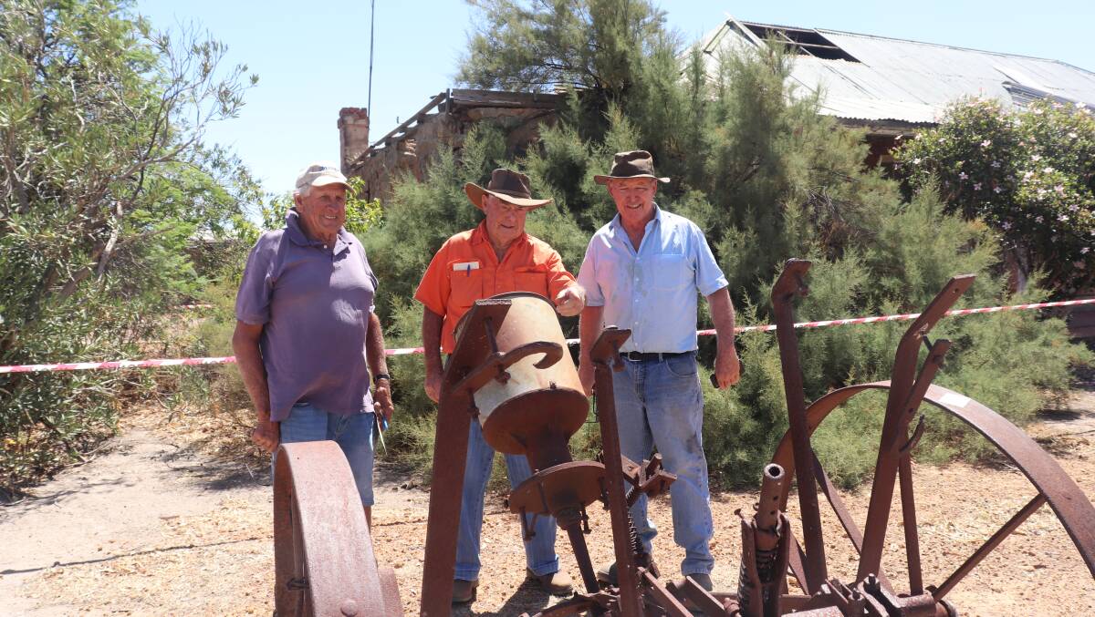 Keith Henderson (left), Kondinin, Kevin Martin, Williams and Michael Reynolds, Tambellup, discuss the possible restoration of a vintage horse-drawn poison cart which would have been used to dispense a mixture of aniseed, phosphorus and bran as bait pellets to kill rabbits in the 1920s and 1930s.