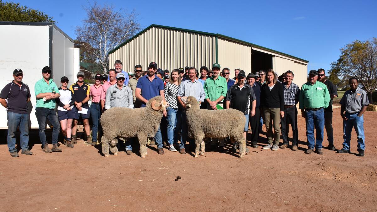 Eastville Park and Quailerup West co-principal Todd (left) and Grantly Mullan hold the $3750 top-priced Quailerup West ram and $5250 top-priced Eastville Park ram surrounded by buyers at the Eastville Park and Quailerup West on-property ram sale at Wickepin.