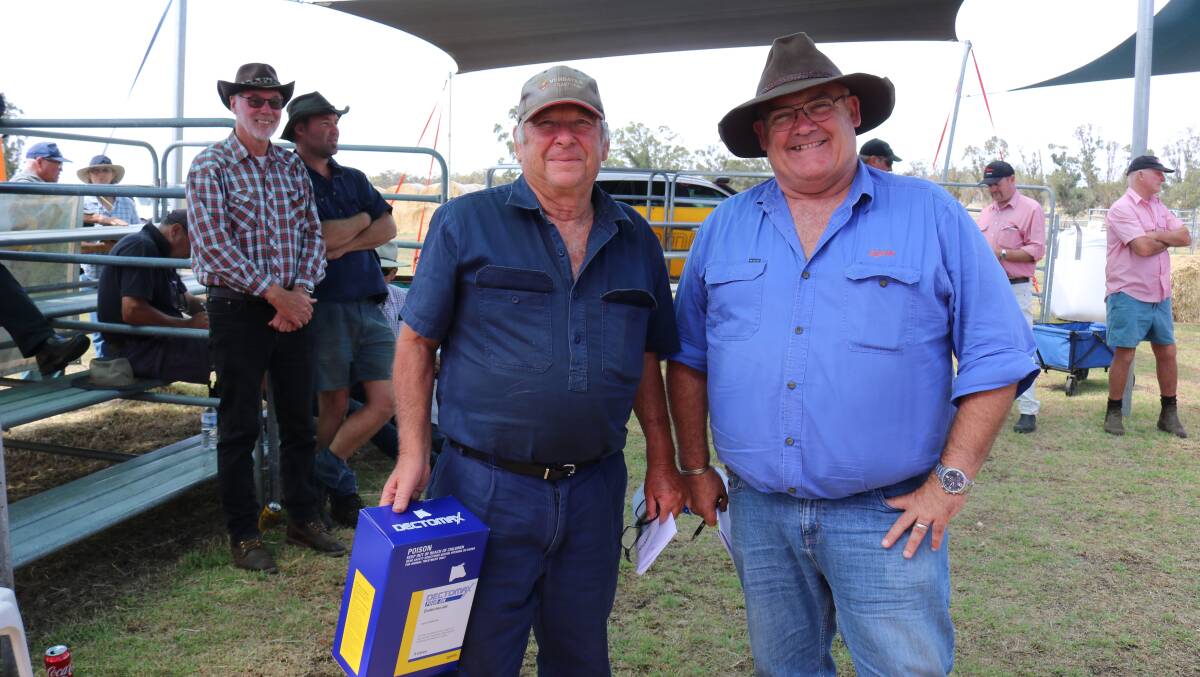  Lucky buyer Neil Johnson (left), Green Valley, won some Dectomax at the conclusion of the sale, donated by Ben Fletcher, Zoetis.