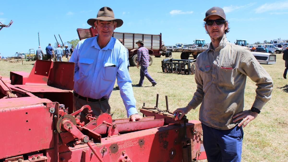 Chris (left) and Patrick Enright, Woodgenellup, inspect a square baler at the clearing sale of RG Woodward, Narrikup.