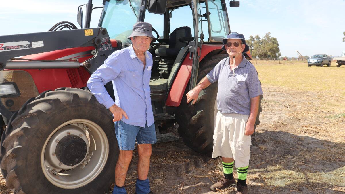 Old mates John Verheyen (left) and John Annear, both of Gingin, check out the bigger of two Case front-end-loader tractors offered at the clearing sale.