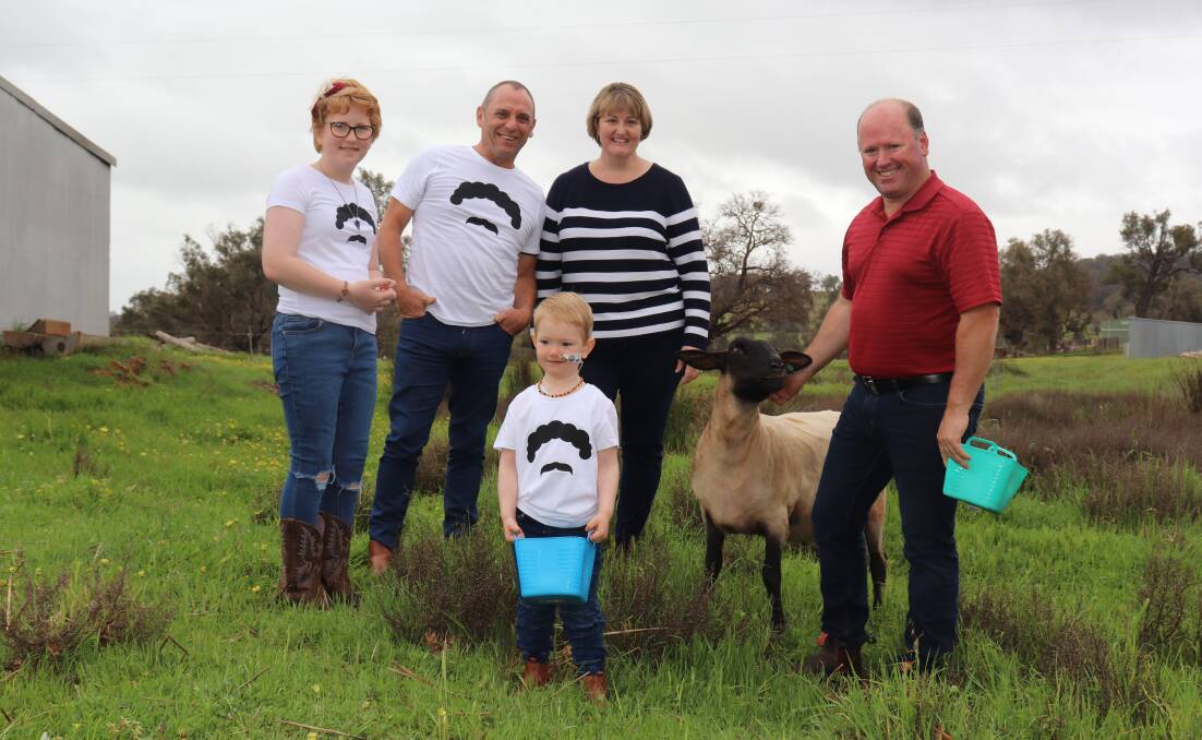 Jamie Sherlock back home with pet lamb Coco, Michael Manion Wool Industry Foundation director Steve Noa (back left) and mum Nicky and dad Les.