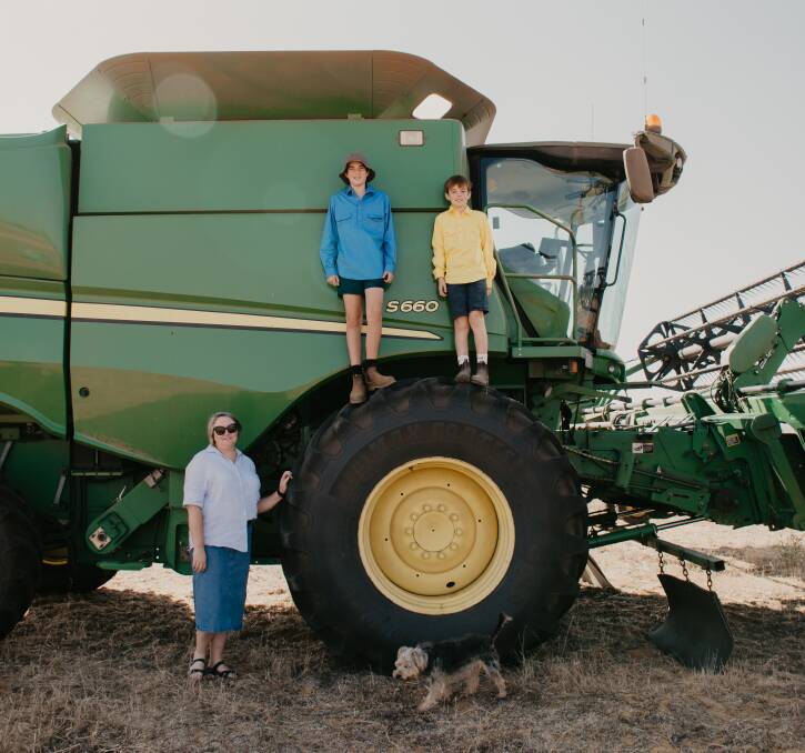 Liz, Henry and Mark Burton stand proudly in front of Jacks John Deere harvester. Photo by Amy Schultz Photography.