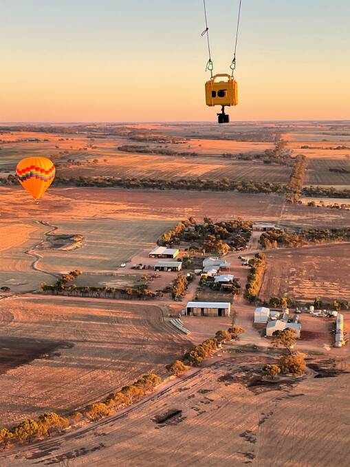 Farm properties take on a different perspective when viewed from a balloon. The yellow box just above the horizon is a camera suspended from the balloon and triggered remotely by the pilot.