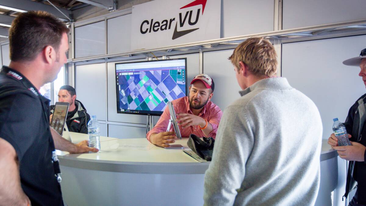 Case IH product manager Andrew Kissel (centre) talks to customers at the AgQuip field days.