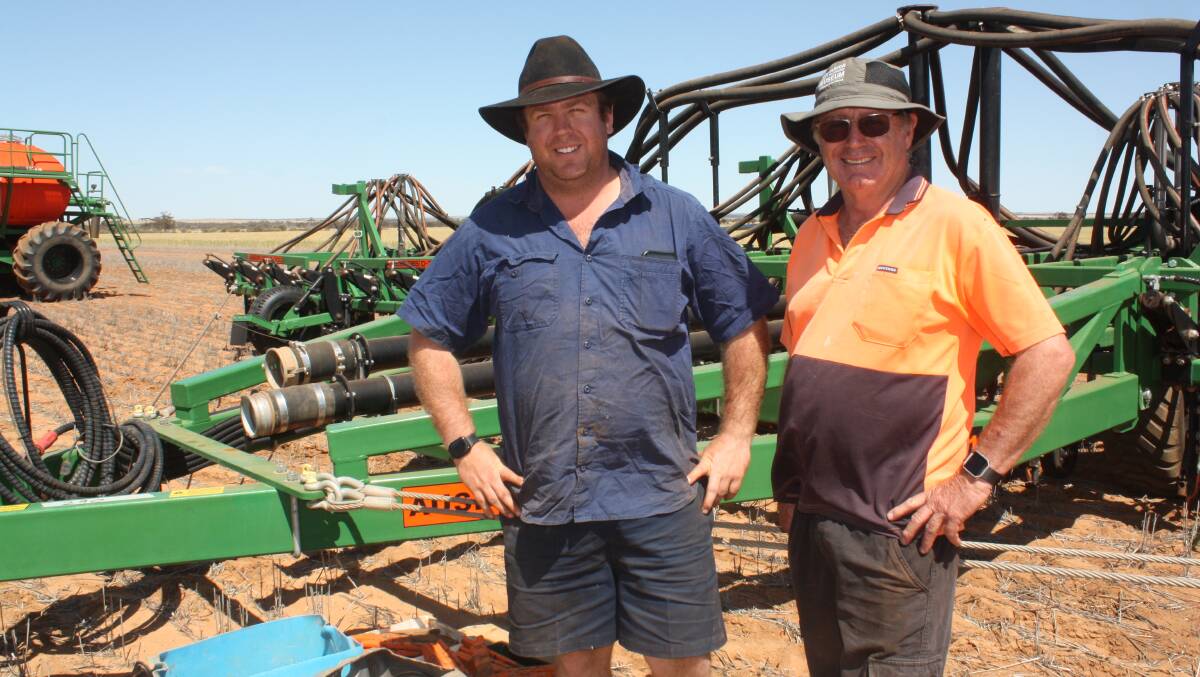  Checking out the top-priced lot at the sale, an 18.2 metre Ausplow DBS D300-61 were local farmers Brayden (left) and Alan Dodd. The precision seeding bar sold for $339,000.