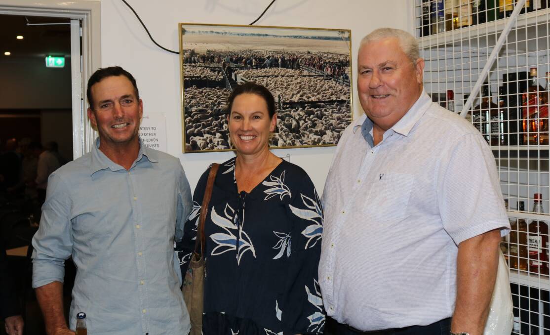 Long-time Elders clients Rodney (left) and Jane Rogers, Tammin, with Kevin Broad, Elders stud stock Northam, in front of a photograph hanging in the Kellerberrin Hotel depicting Adrian Gamble in auctioneering flight at the biggest ever sheep sale held in the town on May 13, 1987,when 10,000 head went under the hammer.