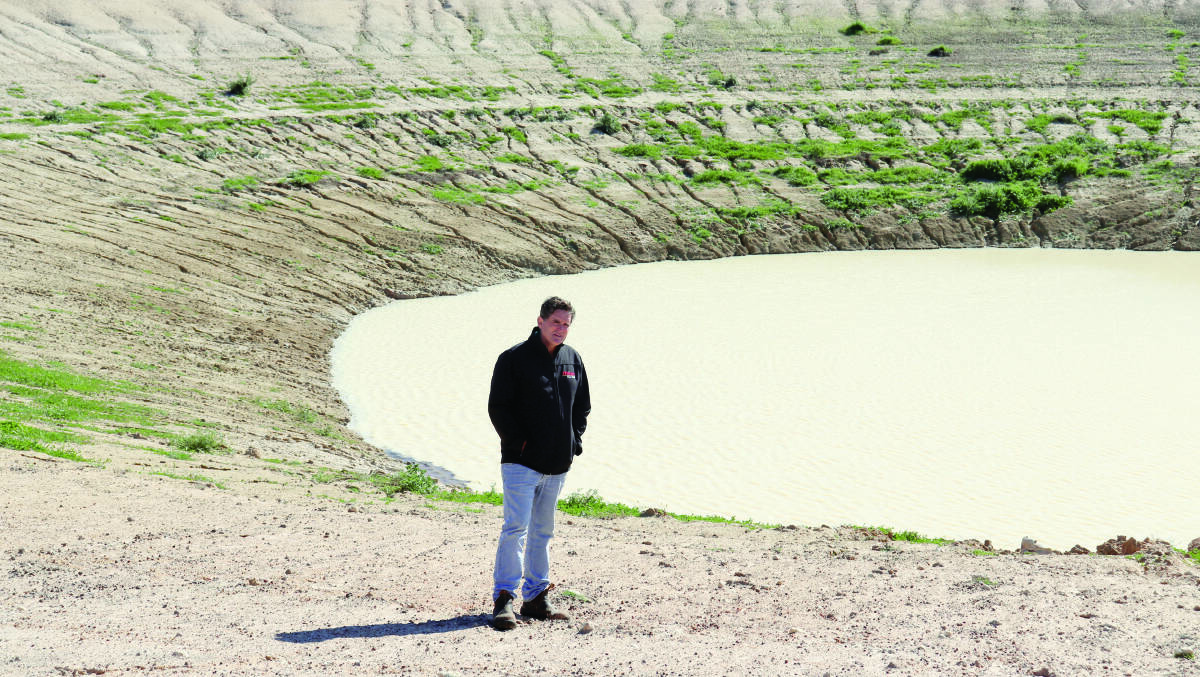  Dunn Rock farmer Chris Walker in his property's main dam which was almost empty after three years of dry seasonal conditions, until a fortnight ago when rain began to replenish it.