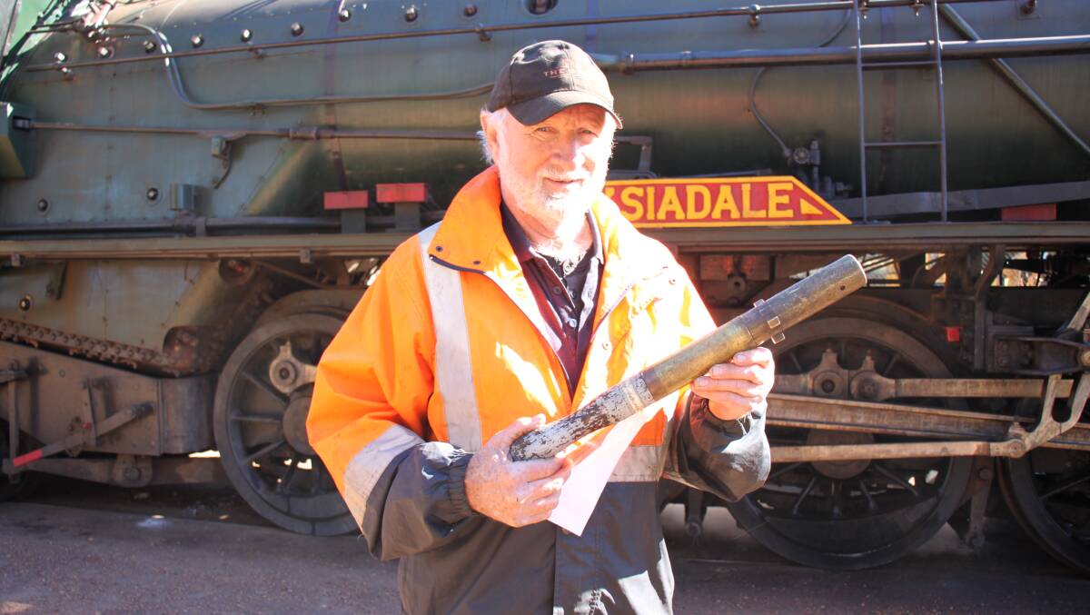 Don Butler was on fire patrol duty, driving behind the steam train along the tracks to ensure no fires were started. He is pictured with the staff, which is used in a train staff system and the possession gives the train permission to enter a block section. The staff is to prevent more than one train being in the section between two staff stations on the same line at the same time. Each train must carry a train staff or staff ticket.