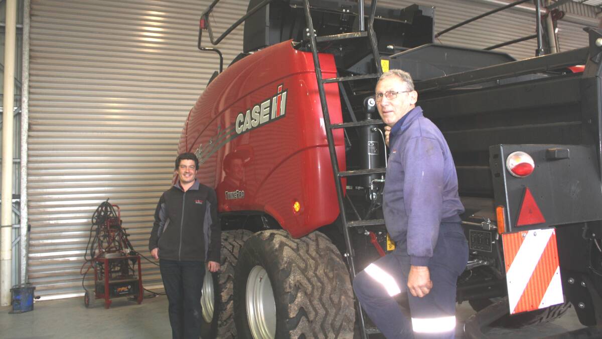 Boekeman Machinery Northam salesman Sam Moss (left) and field service technician (hay and sprayers) Chris Eaton finish off pre-delivery work on this new Case IH LB434XL large square baler at the dealership before it is delivered to a local farmer.