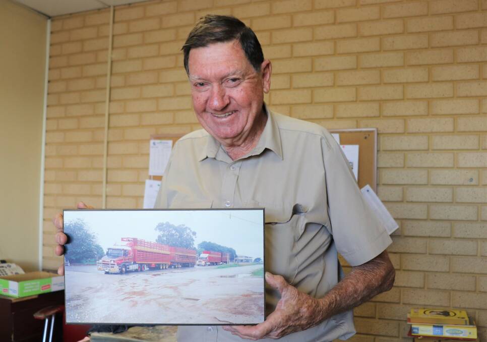 Colin Treasure with a photograph of the company's Scania road-train followed by its Mack road-train.
