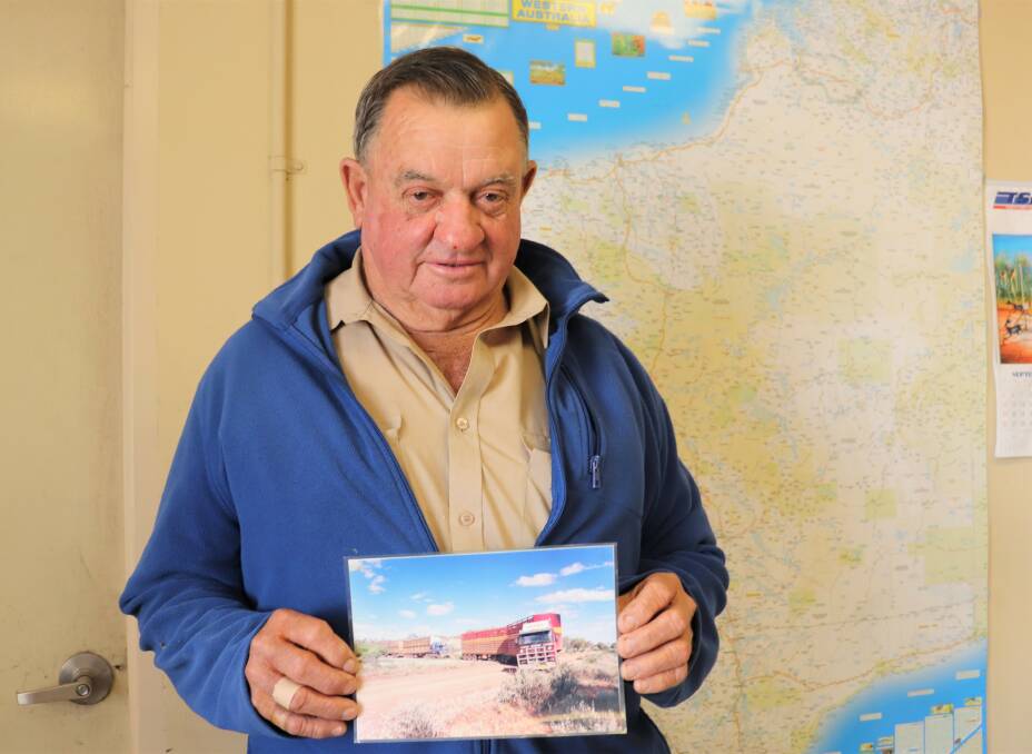 Glenn Treasure with a prized photograph of a Treasures Stock Transport Scania, which was loaded with hay at the time, towing the Mt Vernon station Mack and two stock trailers 40 kilometres, which included several dry creek crossings, back to the station after it broke down.