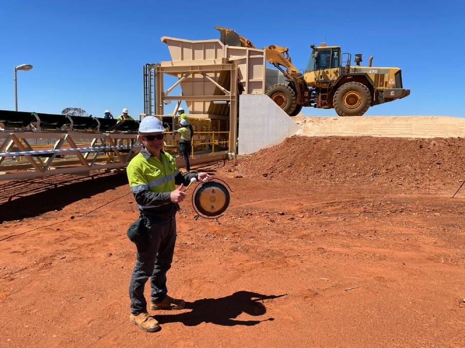 SO4's then chief executive Tony Swiericzuk rings an ornamental Chinese gong to mark the first loader bucket of harvest salts being tipped onto the conveyor to take it up to the still being completed Sulphate of Potash fertiliser processing plant at Lake Way in September last year.