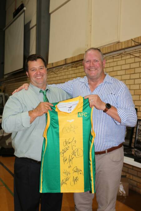 Andrew Lockyer and Northampton Rams football Club senior president Damian Harris with a Northampton Rams jumper signed by the nine Northampton Rams AFL Legends.