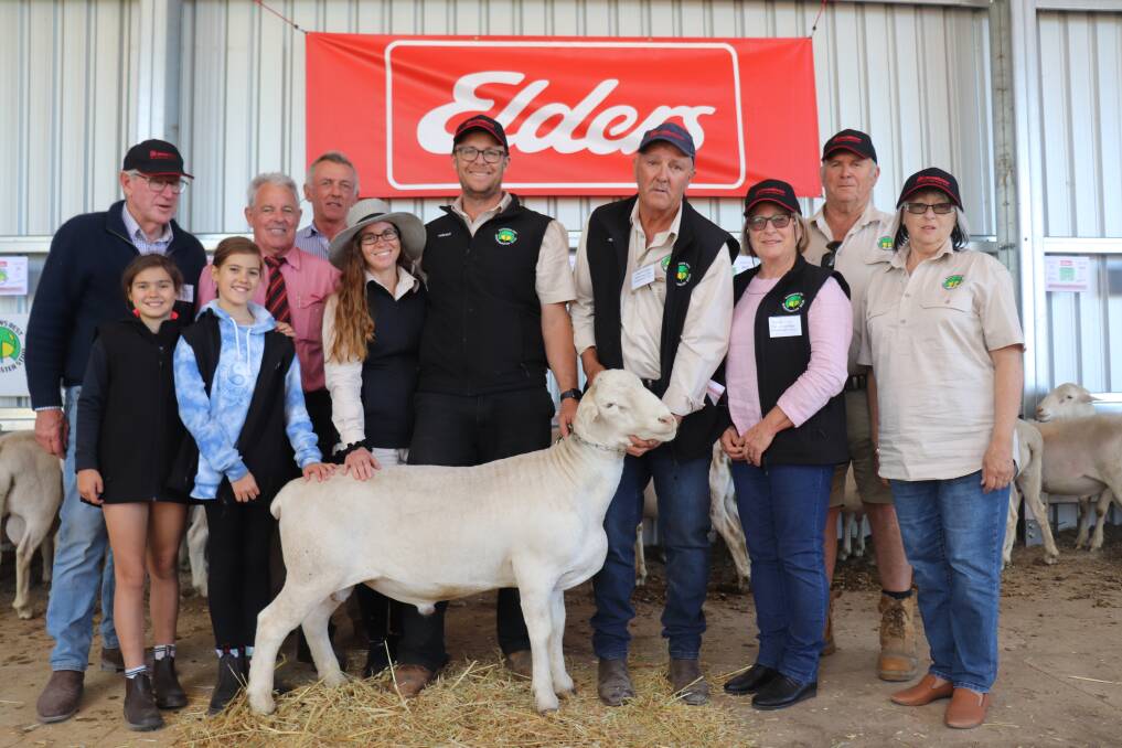 Rainbows Rest SheepMaster stud's $7600 top-priced ram and top price ram of the sale, Samson, with (from back left) SheepMaster breed founder Neil Garnett, Elders auctioneer Preston Clarke, bidder on behalf of buyers SJ & MP Kilby, Tara, New South Wales, Andrew Hodgson, (in front) Indi, 9 and Alyssa, 11, their parents and Rainbows Rest co-principals Jodi and Tristan Reed, Rainbows Rest studmaster Geoff Crabb and his wife Sandy and Rainbows Rest co-principals Des and Sue Reed.