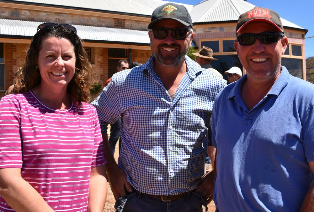 BALE-OUT: Farmer Phil Cook, centre, chats with Jane Smith and Greg Williams at last year's "mercy" delivery of hay. On Monday, an even bigger load will arrive at Mr Cook's property in the drought-stricken district.
