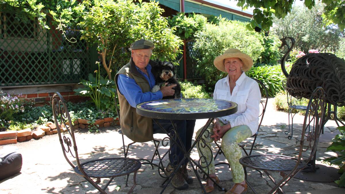 Graham and Verna Harding, with their dog Ivy, in their two hectare masterpiece of a garden with historical buildings at Williams.