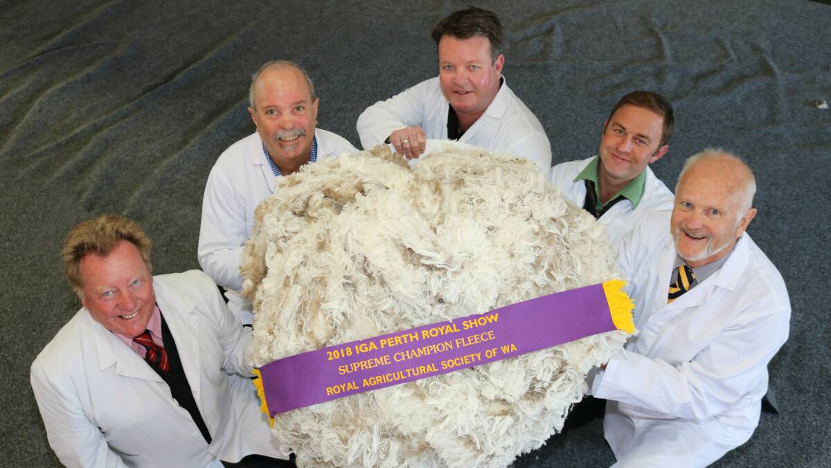 IGA Perth Royal Show wool judges Tim Burgess (left), Elders, Graeme Luff, Primaries of WA, Cameron Henry and Matthew Chambers, Landmark and chief judge Tim Chapman, Primaries of WA, with the 2018 Supreme champion fleece produced by the King family, Rangeview Grazing, Darkan.