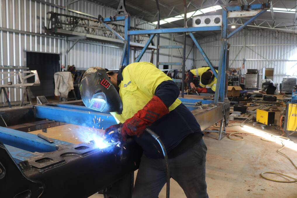 Welder Ashley Thurnwood working on a Calibre boom sprayer chassis at Eagle Eye Engineering.