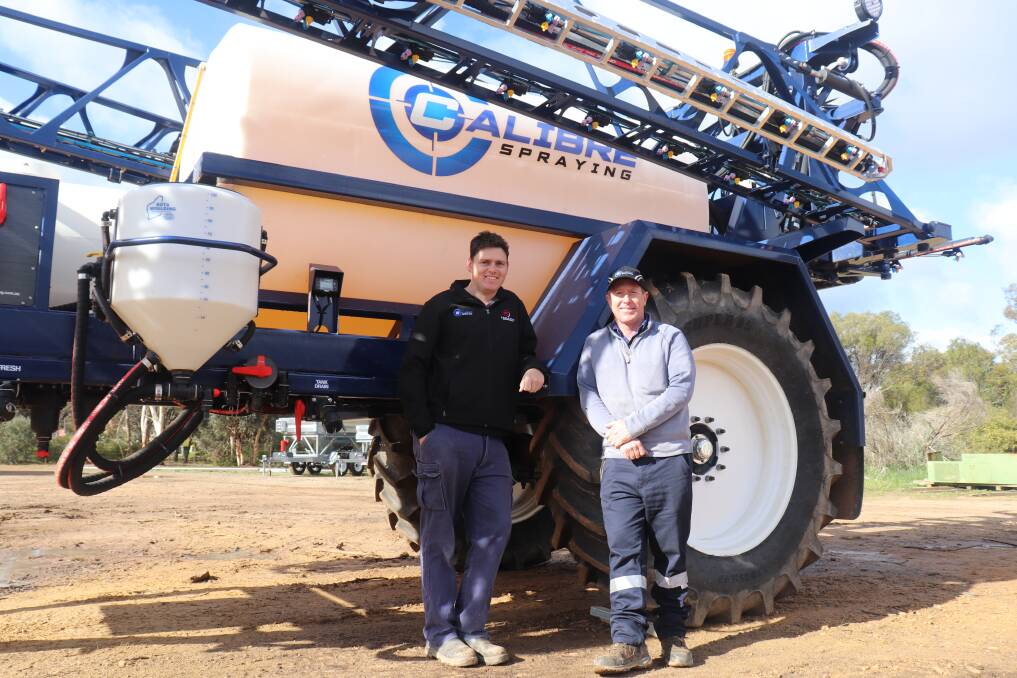 Self-taught Brookton industrial designer Daniel Watkins (left) and business partner and Brookton spraying contractor Scott Morrell with the Calibre towed boomsprayer they designed and now build for customers in agriculture.