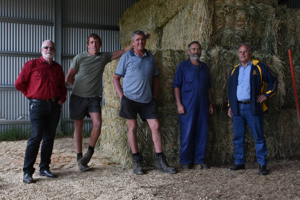 LIFELINE: Mark Livermore, Hastings dairy farmers Riley, Col and Bob Baker and Wauchope Rotary's Reg Pierce with the first of the hay. PHOTO: Laura Telford.